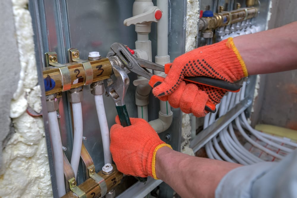 man fixing heating pipes during services